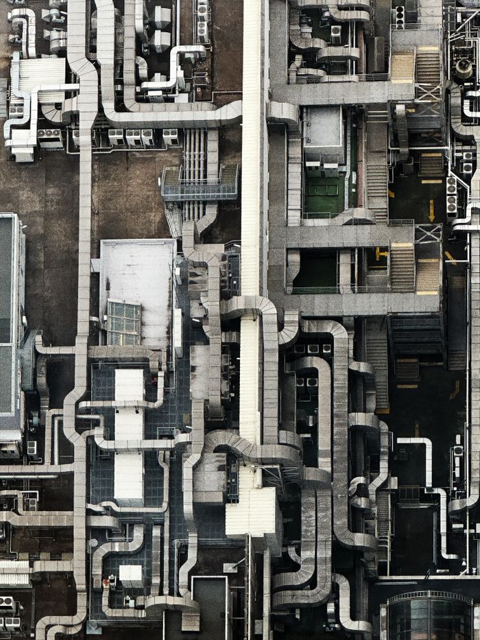 gallery-1 Aerial view showing an intricate network of industrial pipes and structures on a rooftop.