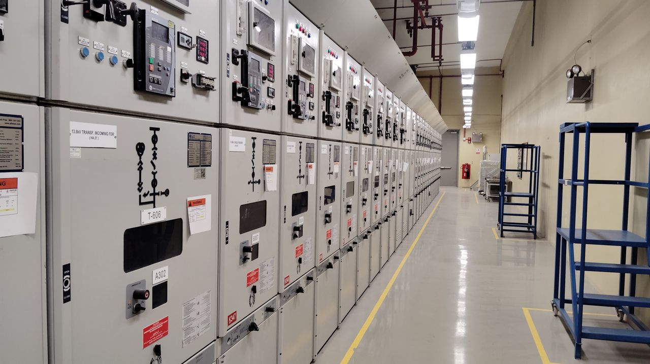 gallery-2 Long row of control panels in an industrial electrical control room, well-lit and spacious.