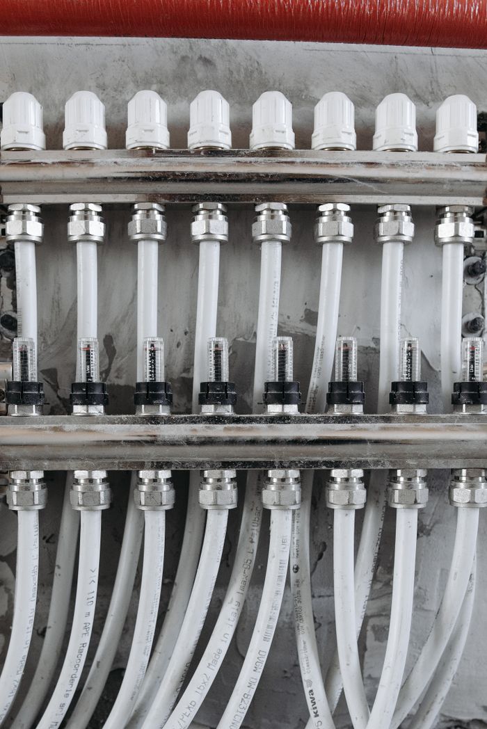 VÌ SAO KHÁCH HÀNG TIN TƯỞNG NAVANDA? Close-up view of an industrial pipe connection system with gauges and valves.
